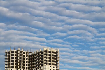 Fototapeta na wymiar A residential building under construction against a beautiful cloudy sky
