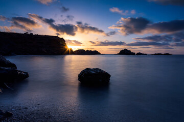 Naklejka premium Beautiful and colorful sunrise from a rocky beach in Cabo de Palos, Murcia, Spain