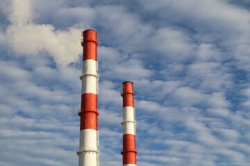 pipes of a thermal power station against a cloudy sky