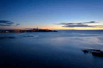Fototapeta premium Seascape of the mediterranean sea and Cabo de Palos city in the background at sunset, Murcia, Spain