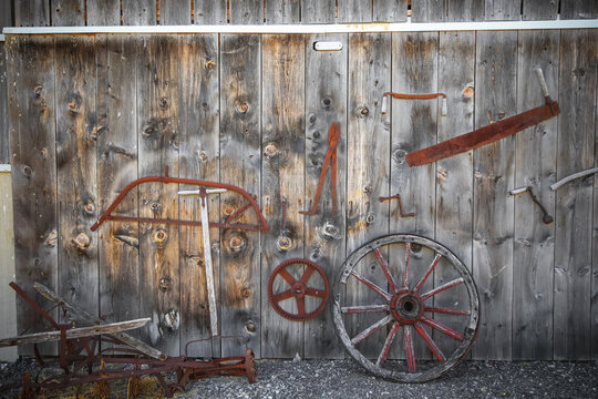 Old rusty tools in on abandoned barn wall.
