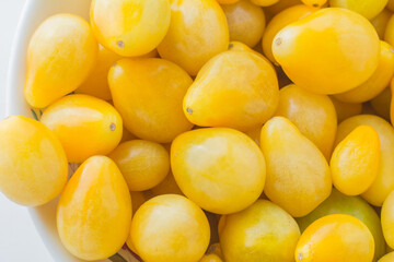 Small yellow pear, isis candy cherry tomato closeup view.