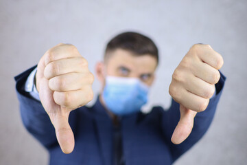a man in a medical mask shows thumbs up hand gestures