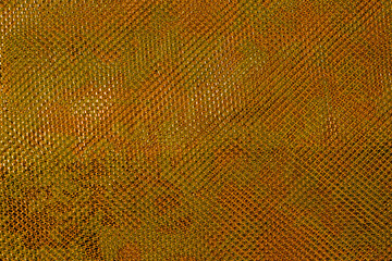 The texture of a thin nylon transparent fabric close-up in Fortuna Gold color. Pattern, background in color trend 2021