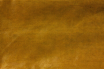 The texture of a thin nylon transparent fabric close-up in Fortuna Gold color. Pattern, background...