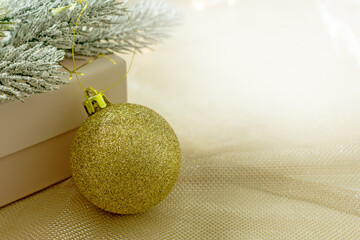 Christmas gold background  with Christmas ball and gift box, copy space. Fortuna Gold color,  color trend 2021
