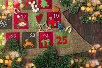 Textile Advent calendar with surprises for Christmas on dark wooden background.