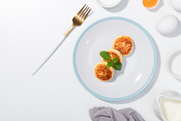 Cottage cheese, eggs, cream and yougurt on a white background - Flat lay with curd pancake - Recipe