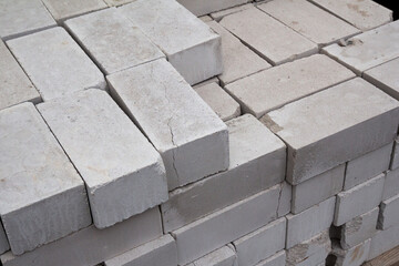 White silicate brick is laid. A pile of defective silicate bricks. Stack of silicate bricks for construction