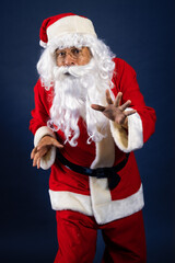 Retrato de papa noel señalando ofertas en traje típico navideño