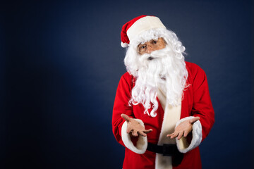 Retrato de papa noel señalando ofertas en traje típico navideño