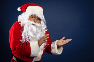 Retrato de papa noel señalando ofertas en traje típico navideño