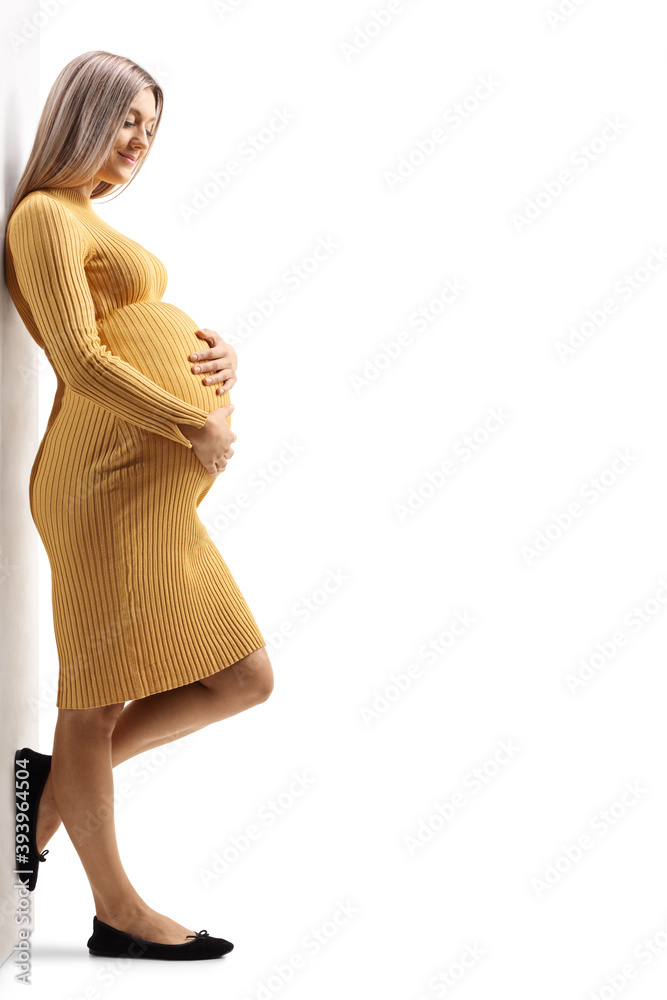 Sticker beautiful pregnant woman in a yellow dress leaning on a wall and holding her belly