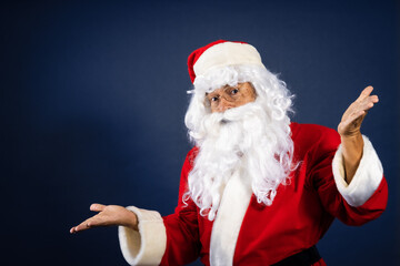 Fototapeta na wymiar Retrato de papa noel señalando ofertas en traje típico navideño