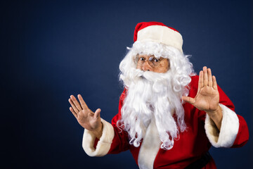 Retrato de papa noel señalando ofertas en traje típico navideño