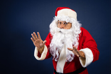 Retrato de papa noel señalando ofertas en traje típico navideño