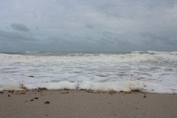 Foamy beach waves against the sand