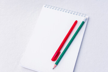 Pencil, pen and notebooks, white background, top view, copy space