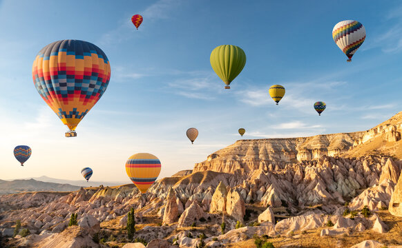 Hot air balloons flying in sunset sky Cappadocia, Goreme, Turkey. Great tourist attraction - sunrise balloning over Cappadocia valleys