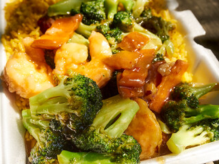 Shrimp with broccoli over fried rice - an iconic Chinese/American takeout dish in a plastic foam container