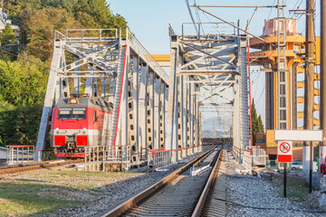 Fototapeta na wymiar Passenger train moves through the bridge. Sochi..
