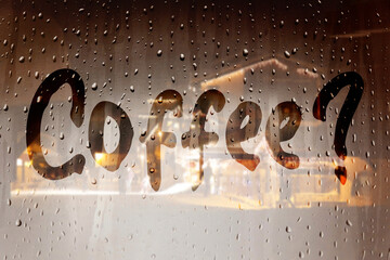 Writing on wet window. The inscription on the sweaty glass - coffee. Coffee on the winter holiday...