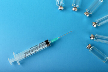 syringe and ampoules on blue background