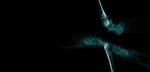 Make up cosmetic brushes with green color powder blush explosion on black background. Skin care or fashion concept.
