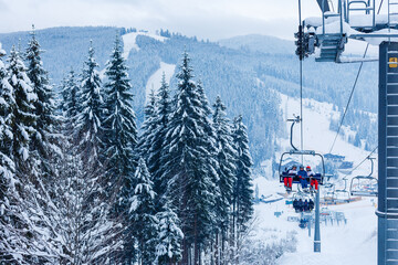 Ski lift - happy skiers in ski resort