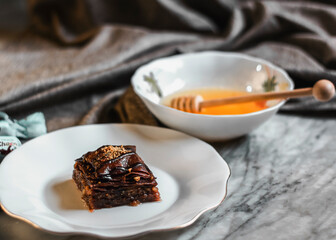 Perfect sweet turkish baklava with pistachio on marble background and wooden honey dipper

