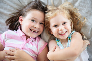 Little Girls Lying on a Bed at Home, Sisters, Childhood Lifestyle Portrait