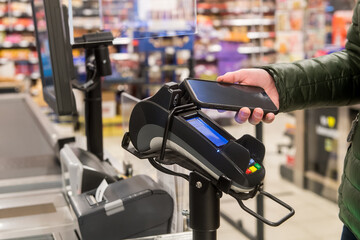 Mobiles bezahlen mit Smartphone im Supermarkt - obrazy, fototapety, plakaty