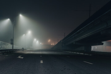 Foggy misty night road illuminated by street lights