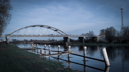Picture of bridge in Poland with blue sky. River above