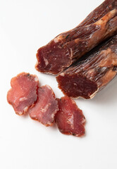 Dried sausage sliced into slices on a white plate. Elite meat product