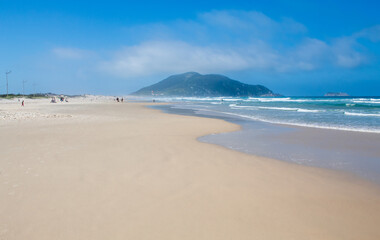 Fototapeta na wymiar areia branca e céu azul em viagem a uma Praia tropical, Praia do Santinho, Florianopolis, Santa Catarina, Brasil, Florianópolis,