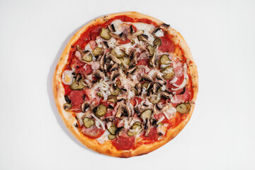 Italian pizza with salami, mushrooms, onions and pickled cucumbers.