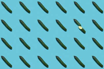 a pattern of cucumbers on a blue background. modern pattern. Healthy vegetarian food. flat lay