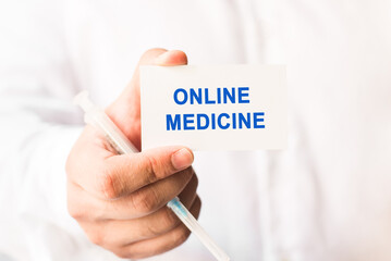 Word online medicine on a white background with a syringe in hand.