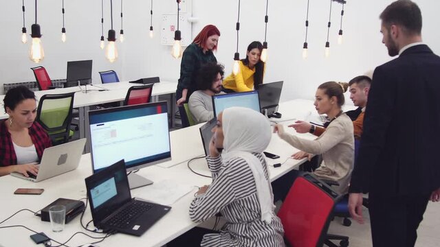 Freelancers team working together ini coworking office. Creative team researching information, planning project. Hipsters friends discussing creative idea in office. Startup. Teamwork.