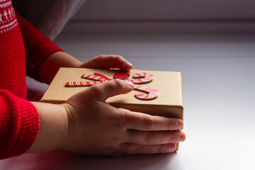 Children's hands are holding a Christmas or New Year's gift box.