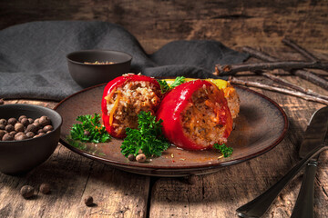 Stuffed peppers in a plate on a wooden brown background. Side view. Concept of culinary backgrounds.