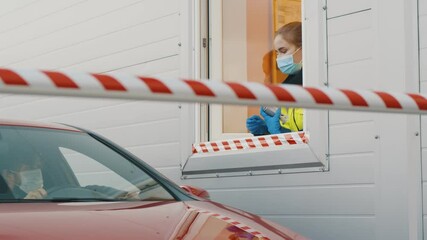 Driver giving passport to worker in booth for passing through border at checkpoint