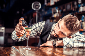 Barman mixes a cocktail in the saloon