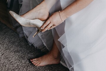 Kobieta panna młoda w dniu ślubu zakłada buty szpilki na obcasie na stopy