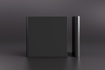 Two hardcover square black mockup books standing on the black background. Blank front cover and spine of book.