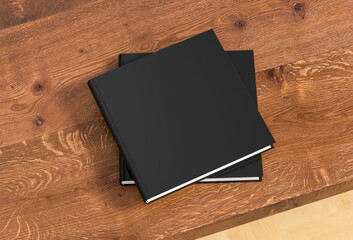 Square black hardcover book stack mockup on the wooden table.