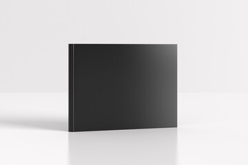 Hardcover horizontal or landscape black mockup book standing on the white background.