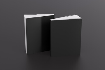 Two softcover or paperback vertical black mockup books standing on the black background. Blank...