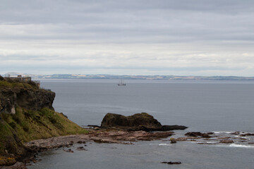 Fototapeta na wymiar Lonely sailboat sailing on the sea, North Berwick, Scotland